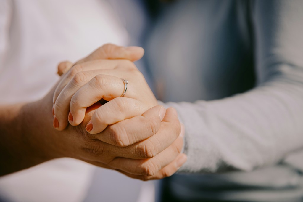 Close-up of two people holding hands in a gesture of support and connection.
Photo credit by Janosch Jost